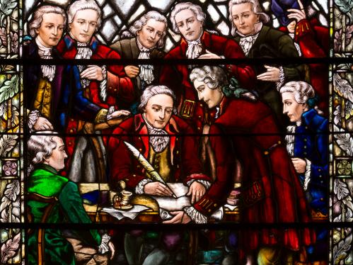 Stained glass window depicting the signing the Queen's College charter