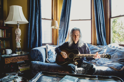 Lenny Kaye in his Victorian home where he practices the guitar.