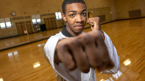 Malik Dobson practices taekwondo in the gym