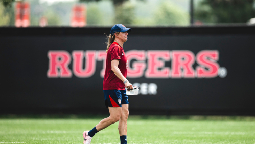 Denise Ready at the Miller Family Soccer Complex with a Rutgers sign in the background