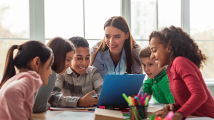 children in school being taught by a teacher