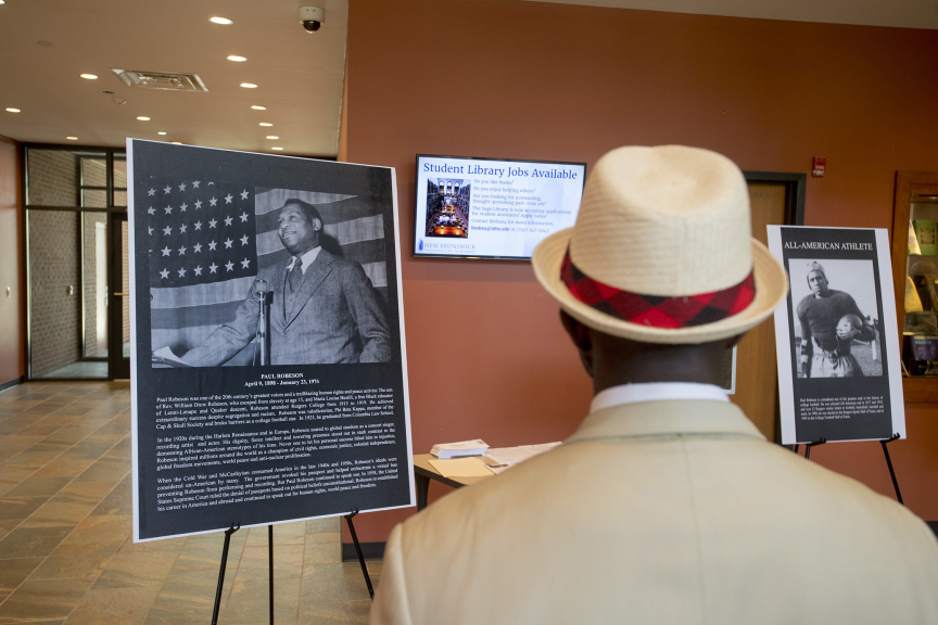 Rutgers Today, Rutgers News - Groundbreaking Honors Paul Robeson’s Legacy as Civil Rights Activist, Rutgers Scholar - Alumnus Alfred A. Edmond Jr., Senior Vice President and Executive Editor-at-Large of Black Enterprise Magazine views posters of Paul Robeson's life at reception following the groundbreaking.