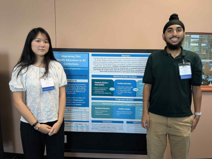 Justice Health program participants Joanna Chan (left) and Prabhjit Sandhu display their summer project during a poster session.