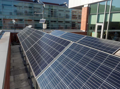 solar panels in the foreground and modern academic buildings are in the background