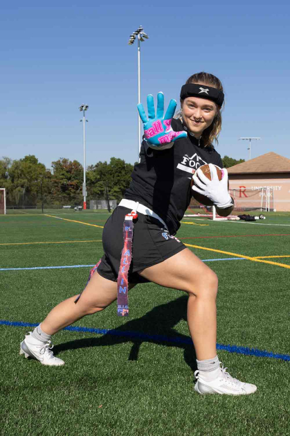 Allison Gandlin, who attends the Rutgers School of Engineering and the Honors College, does the Heisman pose on a sports field at Busch campus.