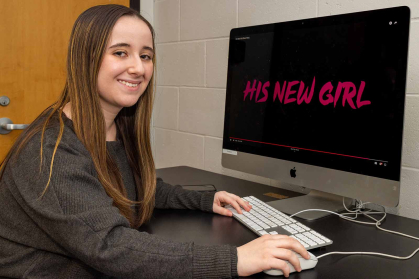 Madeline Hettrick sits before a monitor displaying the title of her short film.