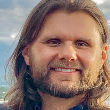 Close up of man with bear with a blue sky in background