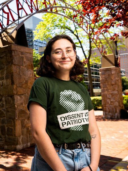 Student standing in front of Rutgers Newark sign.