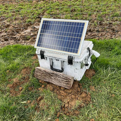 Solar panel on a white box outdoors in a field.